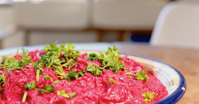 Ein Teller mit türkischem Rote Bete Salat, ganiert mit Kräutern
