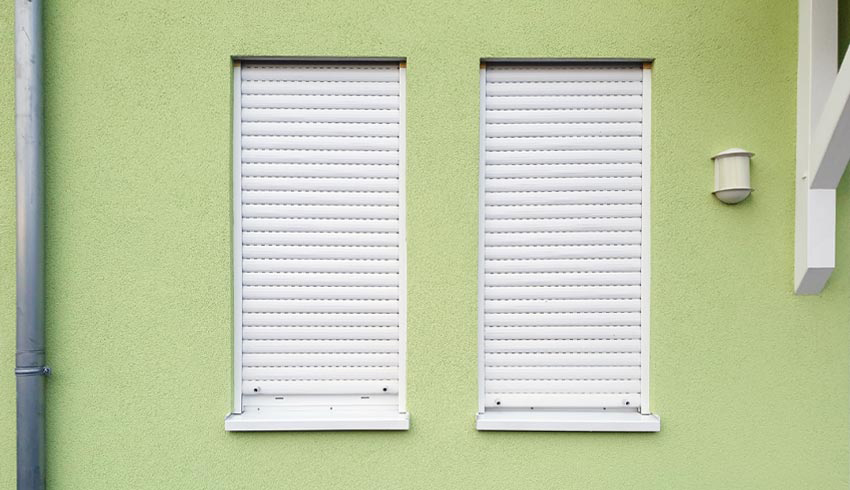 Geschlossene Rölladen eines Frankfurter Wohnhauses mit hellgrüner Fassade