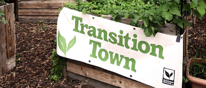 Ein Hochbeet trägt eine Plane mit dem Logo von Transition Town