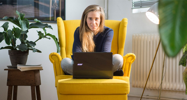 "right. based on science"-Gründerin Hannah Helmke arbeit am Notebook im Schneidersitz auf einem gelben Sessel.