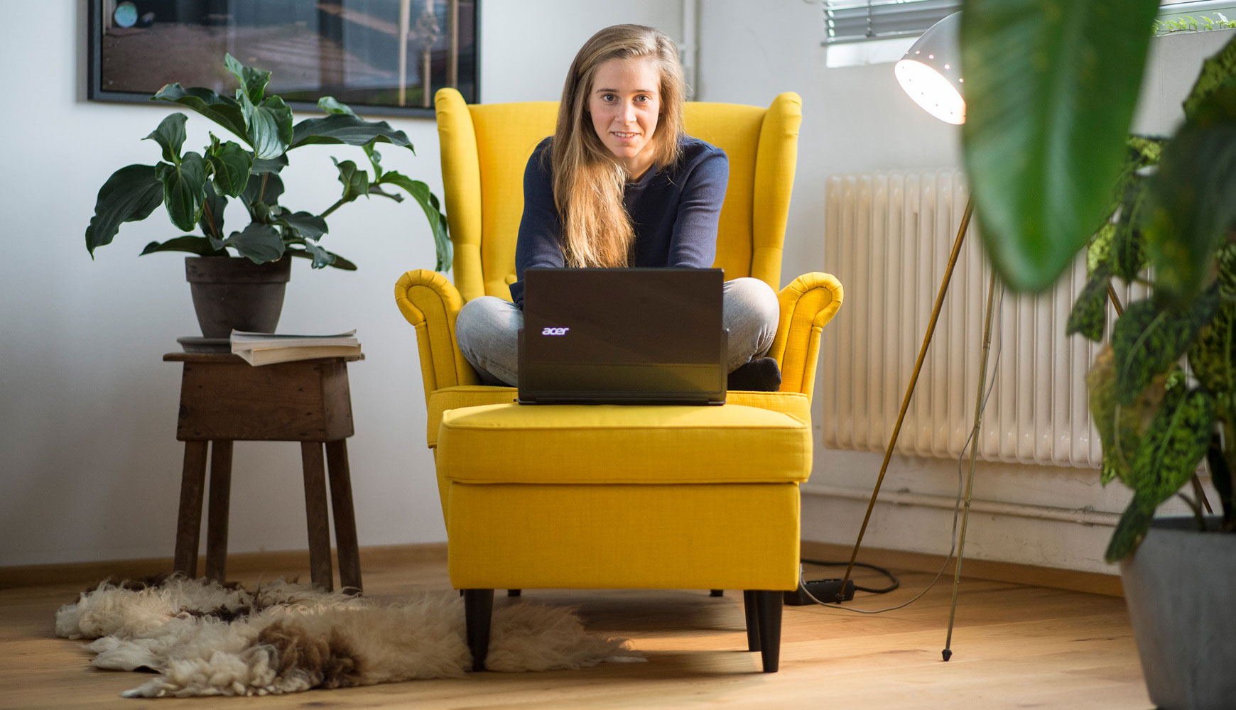 "right. based on science"-Gründerin Hannah Helmke arbeit am Notebook im Schneidersitz auf einem gelben Sessel.